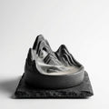 Dark stoneware backflow incense burner with white smoke cascading like mountain fog
